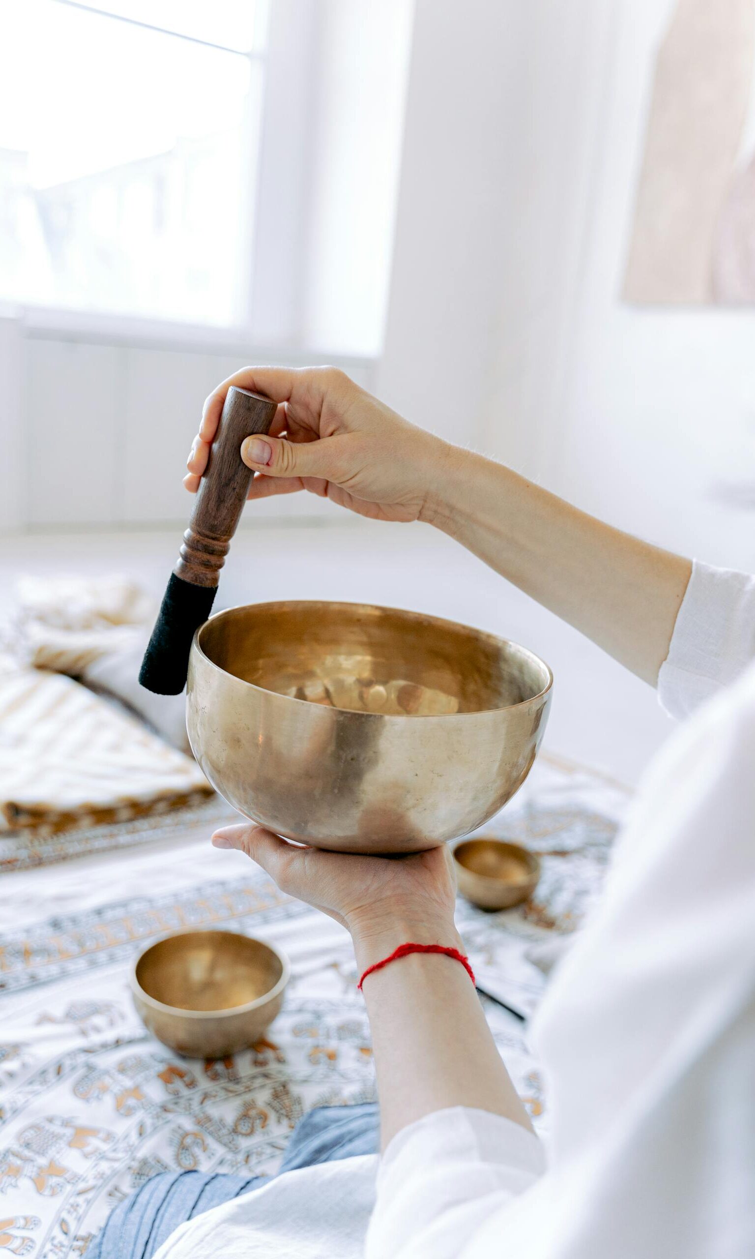 Photo of a Person's Hands Playing a Tibetan Singing Bowl