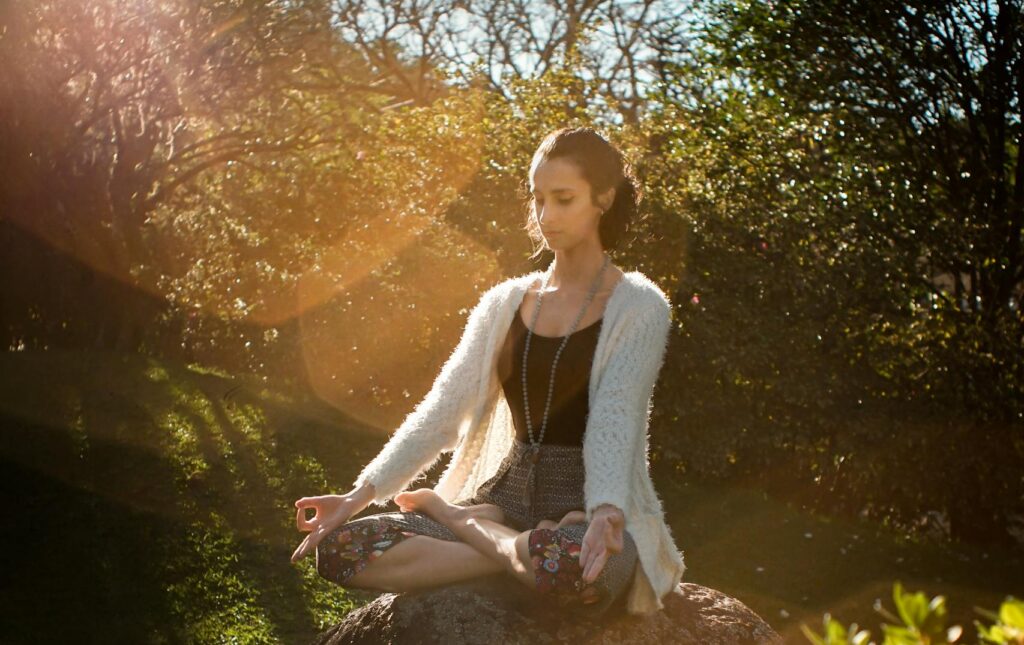 Woman Meditating on Rock